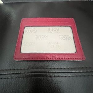 Micheal Kors Leather Card Holder in Burgundy with 3 slots in the front and back.